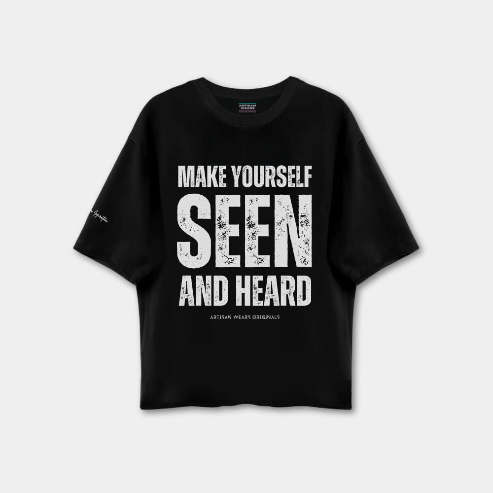 Black t-shirt with white text 'MAKE YOURSELF SEEN AND HEARD' on a light gray background